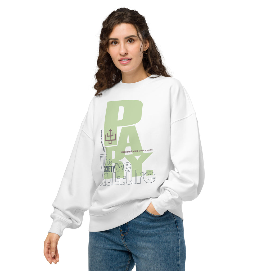 A female model showcasing the front of a white "Pray" organic cotton hoodie by The Society We Kulture. The unisex graphic design is centered on the chest of the high-quality, soft-texture fabric.